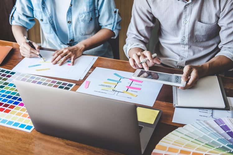 Team of Creative Web/Graphic Designer planning, drawing website ux app for mobile phone application and development template layout, process to developing prototype wireframe, User experience concept.
